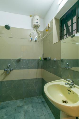 a bathroom with a sink and a mirror at Warmth Lake Haven in Alleppey
