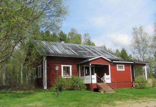 a small red house with a dog on the porch at Ellis Gården in Vemhån