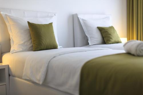 a bedroom with two beds with green and white pillows at Apart Hotel Sea Fort in Sutomore