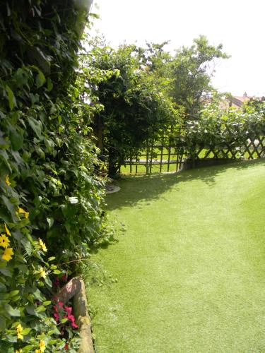 a garden with a gate and some flowers at Maison Landreau in Les Épesses