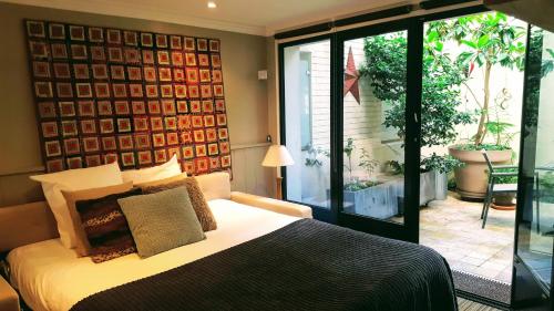 ヌイイ・シュル・セーヌにあるSquare Studioのベッドルーム1室(ベッド1台付)、スライド式ガラスドアが備わります。