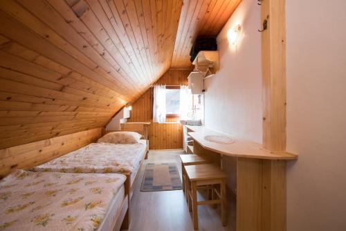 a room with two beds and a desk in it at Rooms Pekovec Bohinj in Bohinj