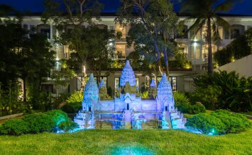 a castle in the grass in front of a building at Damrei Residence & Spa in Siem Reap