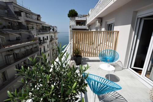 a balcony with two chairs and a view of the ocean at Magnifique Luxury Suites in Thessaloniki