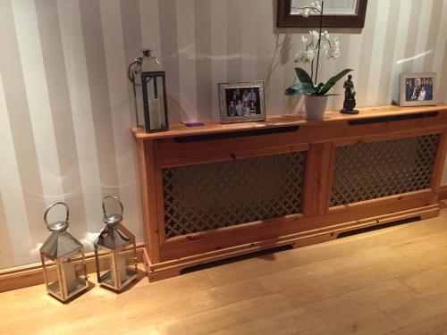 a wooden entertainment center with two candles on top of it at Number Nine Accommodation in Downpatrick