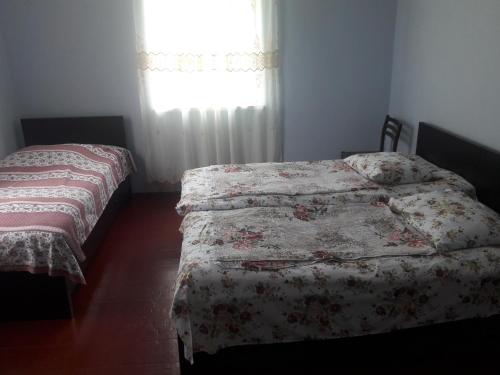 1 dormitorio con 2 camas individuales y ventana en Joni Guest House en Batumi