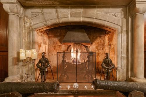 a fireplace with two statues of men on the wall at Barcaldine Castle in Oban