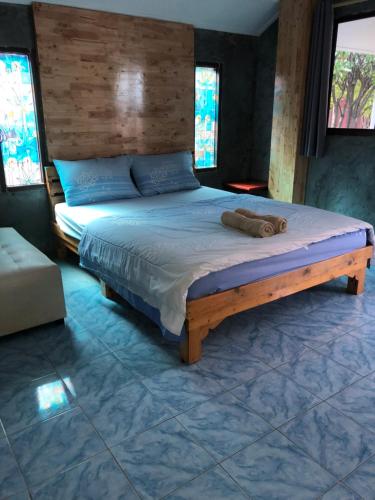 a bedroom with a large bed with a wooden headboard at Poopreaw Koh Larn in Ko Larn