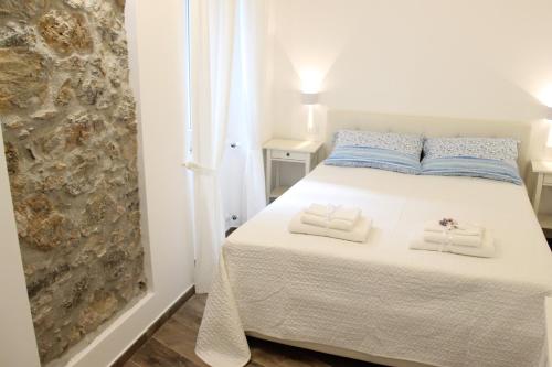 um quarto com uma cama branca com duas toalhas em Casa Maiò em Riccò del Golfo di Spezia
