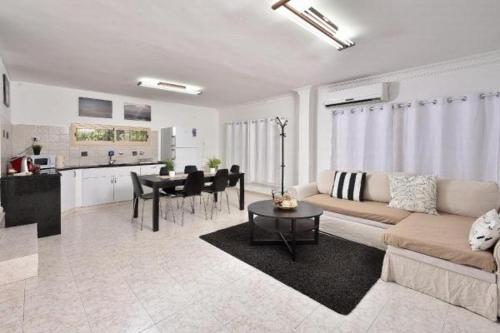a living room with a couch and a table and a kitchen at אחוזת חוף כנרת kinneret village in Tiberias