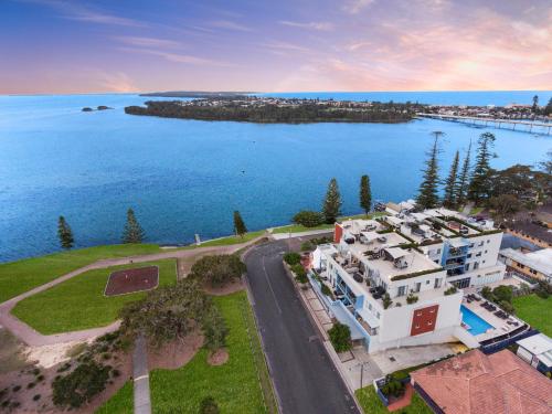 an aerial view of a house next to a body of water at Lakeside Waterfront Apartment The Entrance in The Entrance