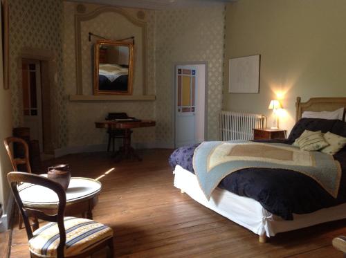 a bedroom with a bed and a table and a desk at Chateau de Laric in Chabestan