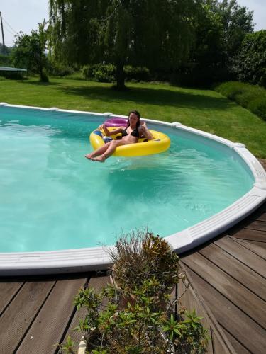 a young boy laying on a raft in a swimming pool at Maison Marie in Poperinge