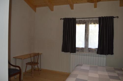 a bedroom with a bed and a table and a window at Lo Cel De Tolo in Toló
