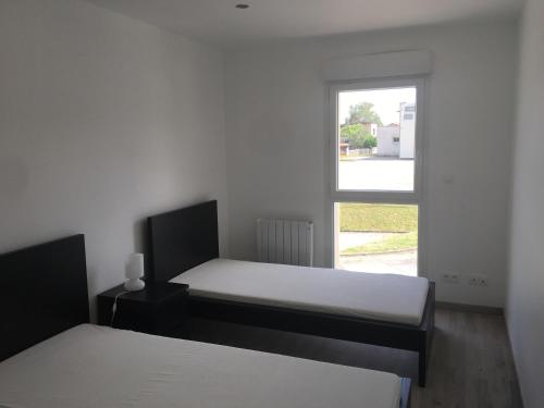 RoiseyにあるAppartement confortable et spacieuxの窓付きの部屋 ベッド2台