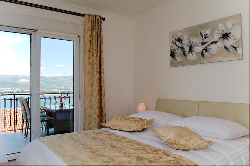 een bed met 2 kussens in een slaapkamer met een balkon bij Apartmani Gaby in Trogir