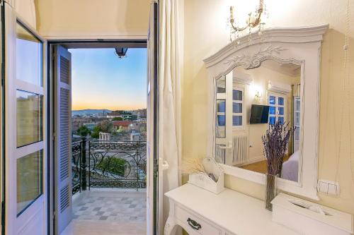 a bathroom with a mirror and a balcony with a view at Aerides Luxury Suites in Athens