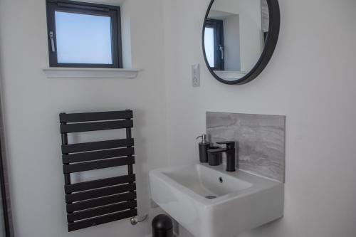 a bathroom with a sink and a mirror at Stay on the Bay, Skye in Broadford