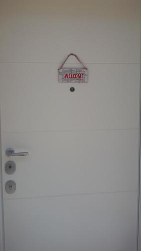 a white door with a welcome sign on it at B&B Honey Rooms in Saronno