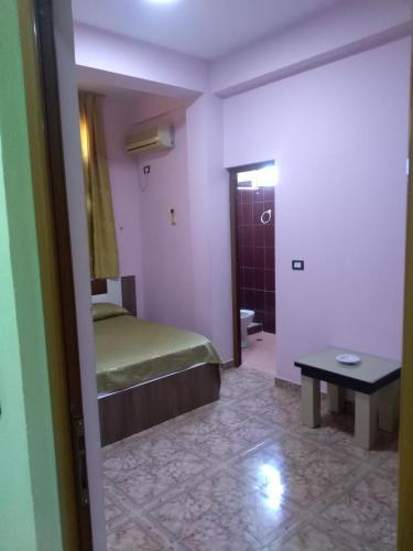 a bedroom with a bed and a table in a room at Hotel Gjeli in Fier