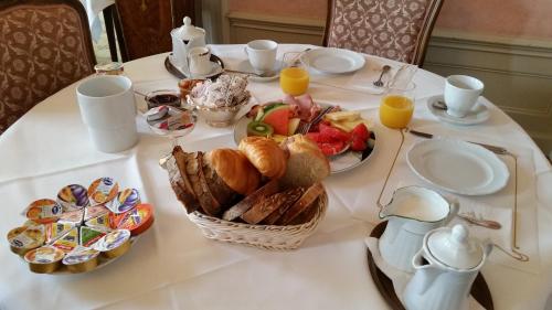 a table with a breakfast of croissants bread and orange juice at Hotel Park Villa in Schaffhausen