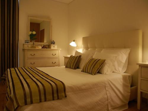 a bedroom with a large white bed with two pillows at Casa Da Trigueira in Santa Eugénia
