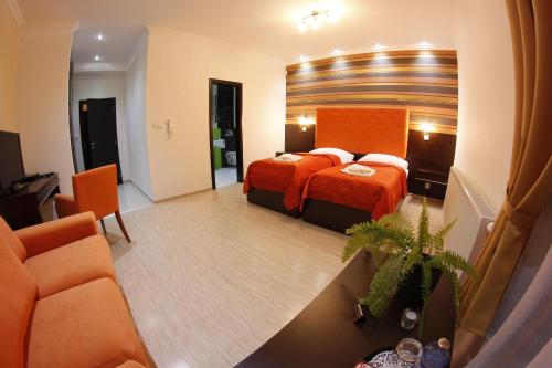 a hotel room with a bed and a couch at Alnus Penzion in Smilno