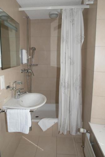 a bathroom with a sink and a shower curtain at Gasthof Seefeld in Hurden