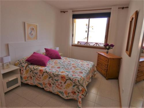 ロス・クリスティアーノスにあるPlaya Lux Los Cristianosのベッドルーム1室(紫色の枕が付くベッド1台、窓付)
