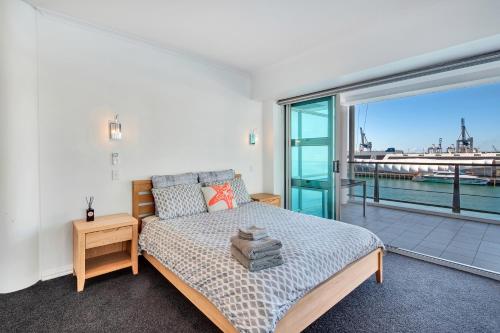 a bedroom with a bed and a balcony at Stunning Harbour & City View Studio l AIRCON & WIFI in Auckland