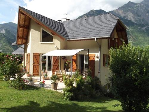 ein kleines Haus mit Bergen im Hintergrund in der Unterkunft Maison in Montricher-le-Bochet