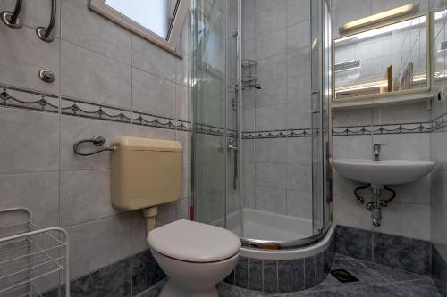 y baño con aseo, lavabo y ducha. en Apartments Roza, en Makarska