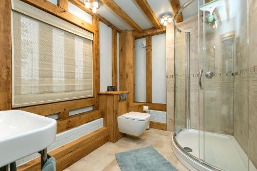 a bathroom with a toilet and a shower and a sink at Corner Farm in Halesworth