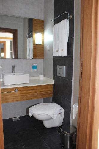 a bathroom with a white toilet and a sink at Çeşme Farm Hotel in Çeşme
