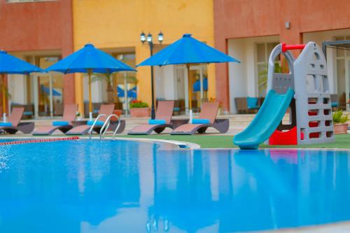 a pool with chairs and umbrellas in it at Tolip Family Park Hotel in Cairo