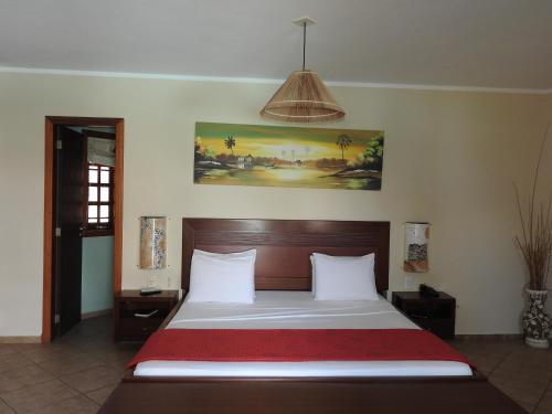 a bedroom with a large bed with a red blanket at IL Nuraghe in Canoa Quebrada