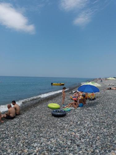 a group of people sitting on a rocky beach at Hotel Georgia in Gonio