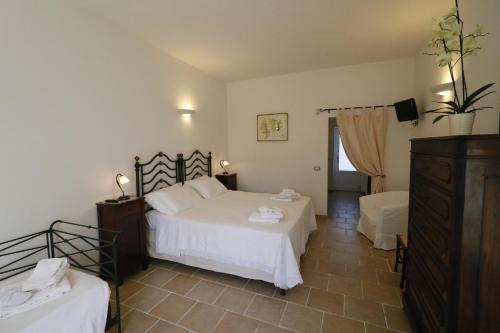 a bedroom with two beds and a dresser in it at Masseria Carignani in Tuglie