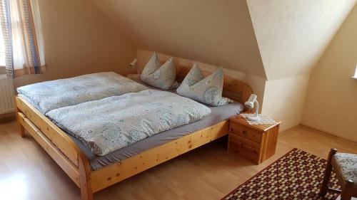 Schlafzimmer mit einem Bett mit einem Holzrahmen und einem Tisch in der Unterkunft Café Hausnordlicht - Ferienwohnung 1 in Dornum