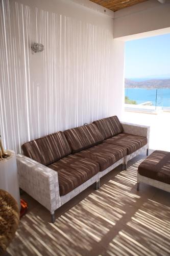 a couch in a room with a large window at Villa Estée, luxury villa with private infinity pool and jacuzzi in Elounda