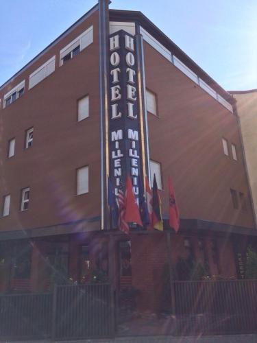 a building with a hotel sign and flags in front of it at Hotel Millenium2 in Prizren