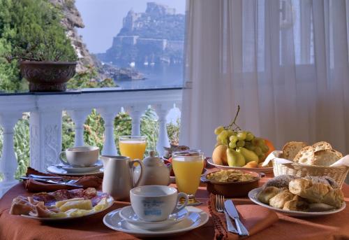 una mesa con desayuno de comida y zumo de naranja en Hotel Da Maria en Isquia