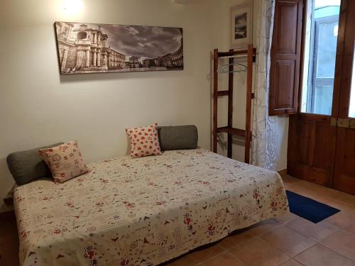 a bedroom with a bed and a picture on the wall at Appartamento Aretusa in Siracusa