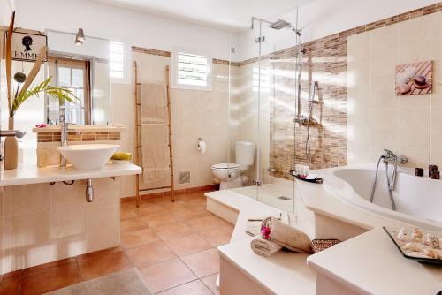 La salle de bains est pourvue d'une baignoire, de toilettes et d'un lavabo. dans l'établissement La villa des cannes, à Sainte-Marie