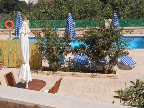 a pool with chairs and umbrellas in front of a pool at Metochi Villas in Spílion
