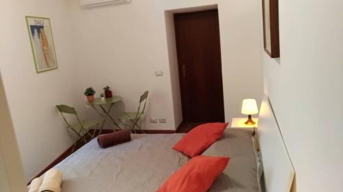 ein Schlafzimmer mit einem Bett mit roten Kissen darauf in der Unterkunft A casa di Lori in Catania