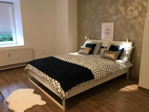 a bedroom with a bed with a black blanket and pillows at Jure apartment in Ljubljana in Ljubljana