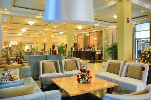 a lobby with chairs and a table in a building at Swiss Inn Nexus Hotel in Addis Ababa