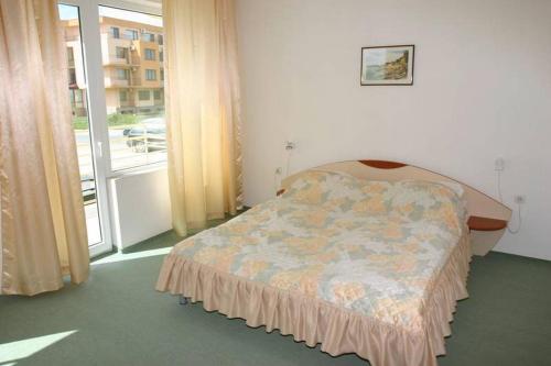 a bedroom with a bed in a room with a window at Harmony Beach Family Hotel in Nesebar