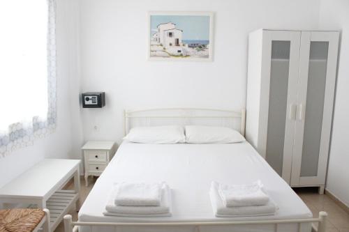 una camera con letto bianco e armadio bianco di Mare Blue Ios a Ios Chora